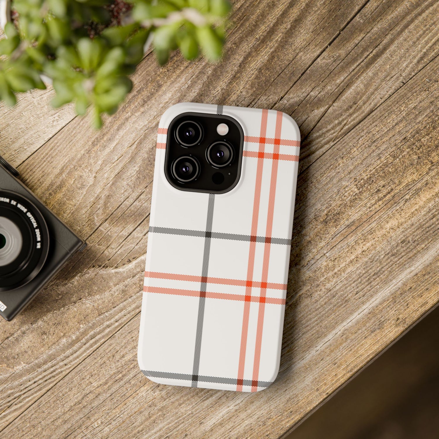A phone case with a fall tartan plaid pattern in white and orange stripes, featuring a camera module in the center.