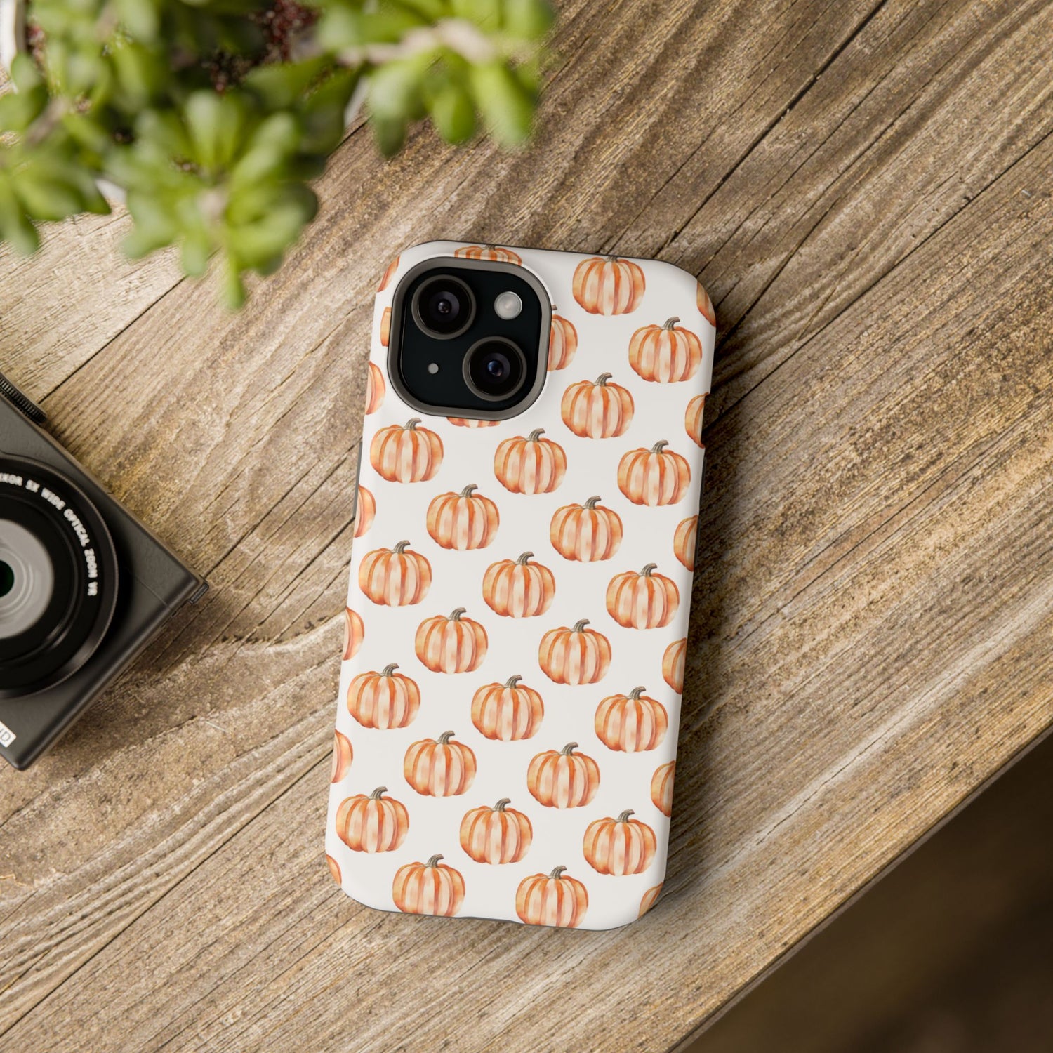 A phone case with a pattern of pumpkins on a white background, featuring a camera cutout and a black border at the top.